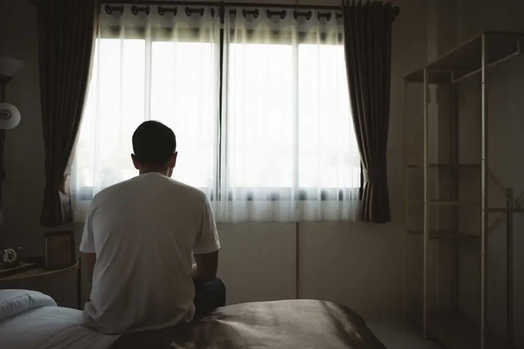 Depressed Man Sitting on Bed