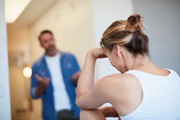 A couple having conflict, man gesticulating, woman sitting