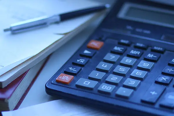 Calculator next to pen and paper