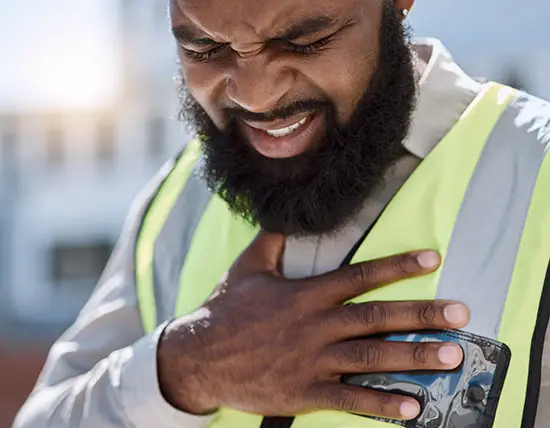 Bearded construction worker clutches chest
