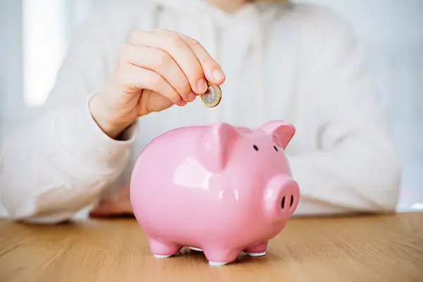 Woman putting money in piggy bank