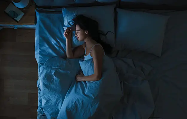 Top view of young woman sleeping in bed