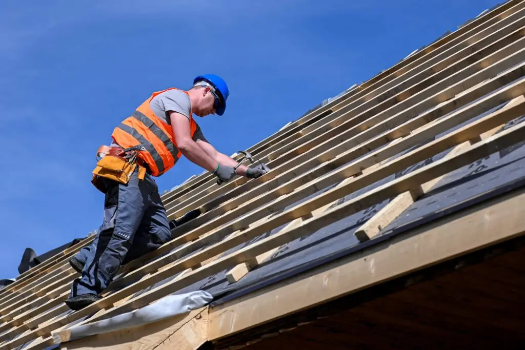 A roofer works on a roof