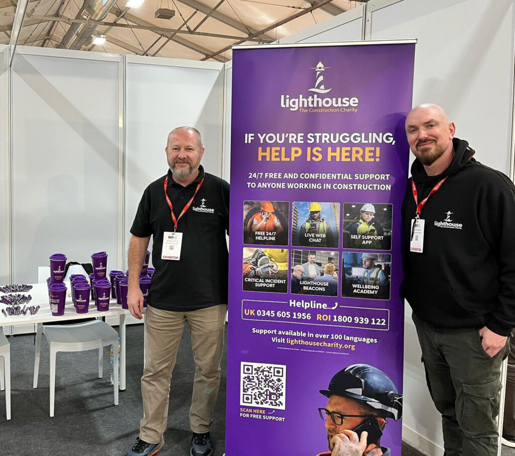 Become a Volunteer for the Lighthouse Charity - Picture shows 2 men standing at an exhibition stand to talk about our charitable services