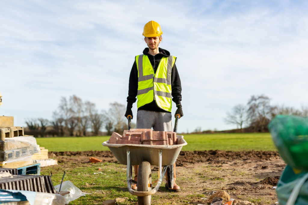 A Young Adult Male Builder Wearing A High Visibility Vest
