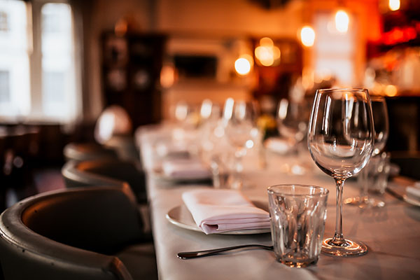 A close up shot of a restaurant table set up with tableware and wine glass. Concept of dining, hospitality and catering.