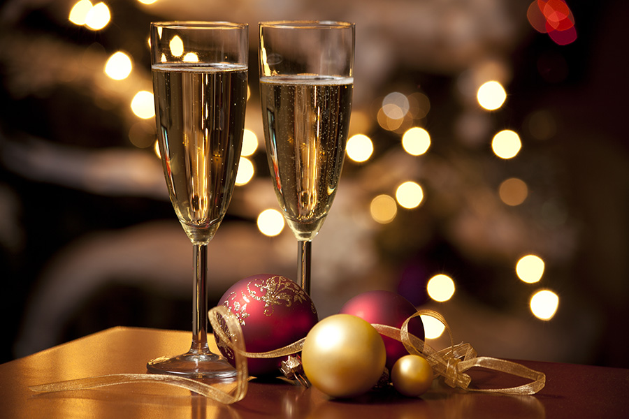 Ribbon, baubles and wine against Christmas lights
